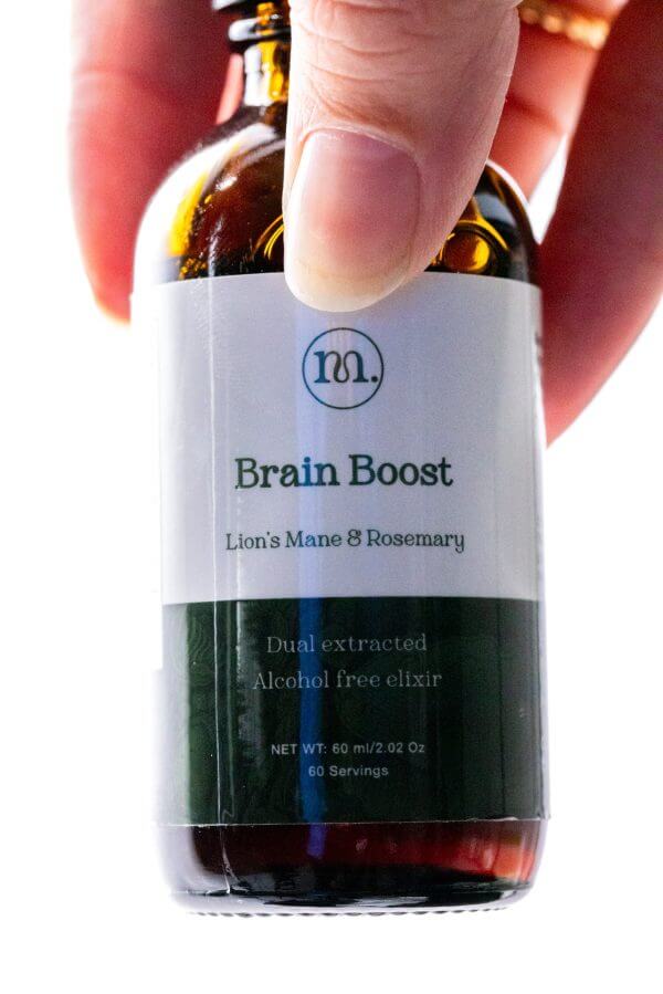 Bottle labeled 'Brain Boost' held by a hand with a white label