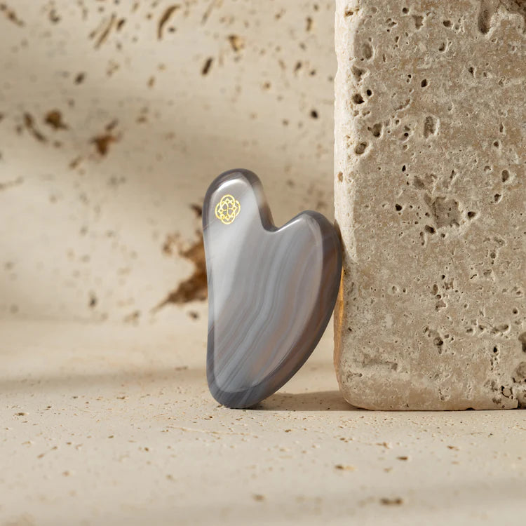 TheAgeHack Gua Sha Agate Crystal on a textured beige background