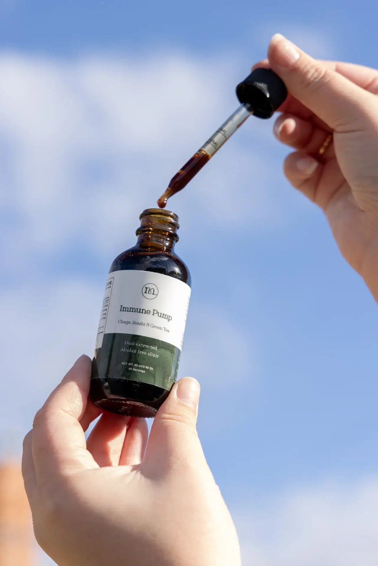 Bottle of 'Immune Prodigy' with dropper against a blue sky background