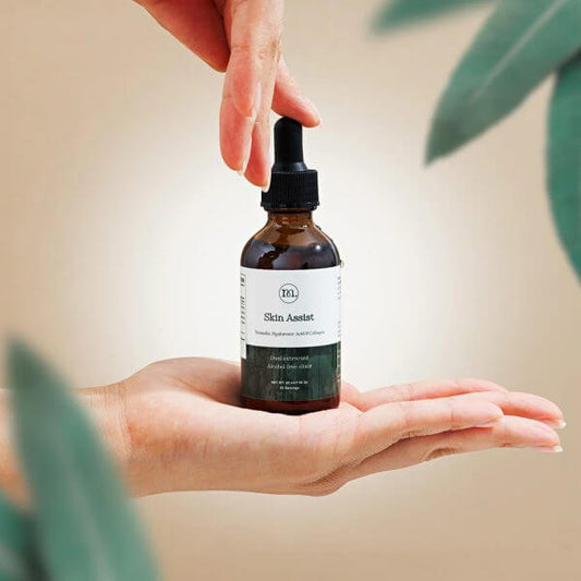 Hand holding a bottle labeled 'Skin Assistant' with a blurred background